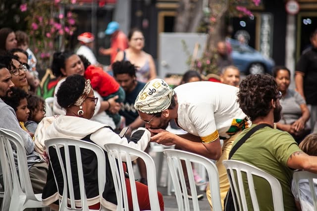 Homem beijando a mão de uma senhora em um projeto de rua.